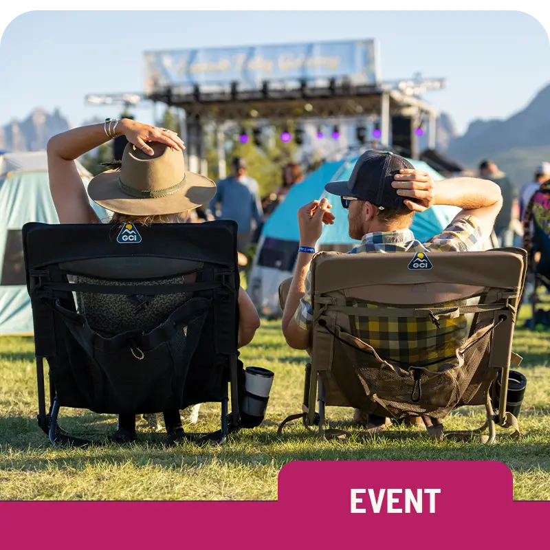 A man and a woman sit in Everywhere Chair 2 chairs at an outdoor concert, with tents and a stage in the background. "Event" label at the bottom.