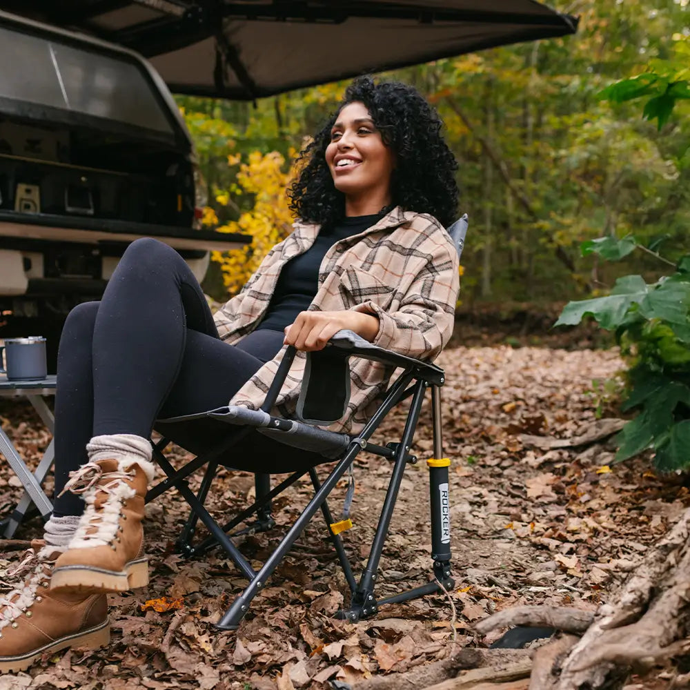 A woman in plaid long sleeves sitting in a roadtrip rocker. 