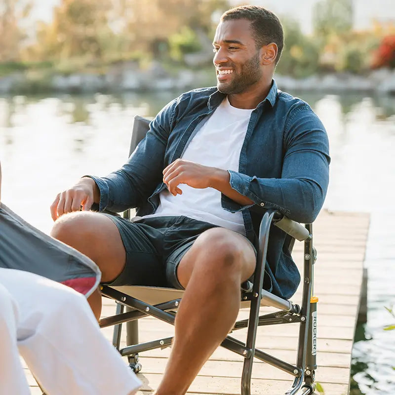 A man sitting in a Firepit Rocker chair on a dock. 