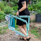 A woman carrying a teal sundress freestyle rocker elite with the integrated carry handle. 
