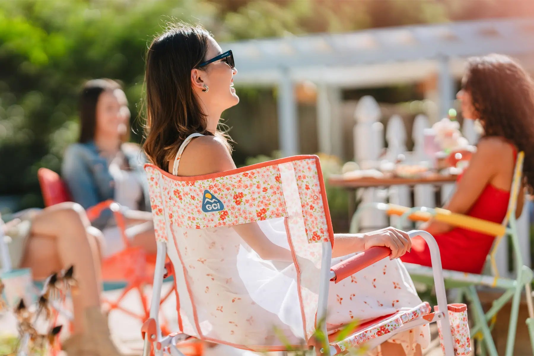 Close-up of the leg of a GCI Freestyle Rocker chair at an outdoor festival with a mountain backdrop.