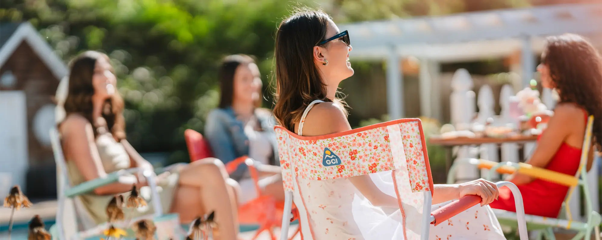 Close-up of the leg of a GCI Freestyle Rocker chair at an outdoor festival with a mountain backdrop.