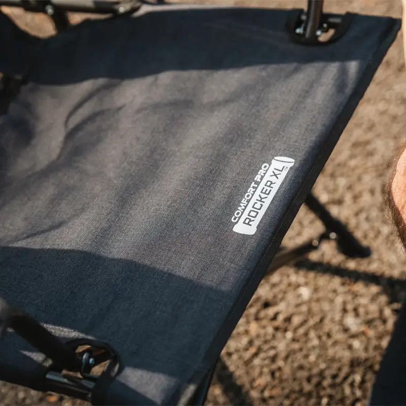 A close-up of the Comfort Pro Rocker XL wide seat, highlighting its durable fabric and spacious design. The chair provides extra room and comfort for outdoor relaxation.