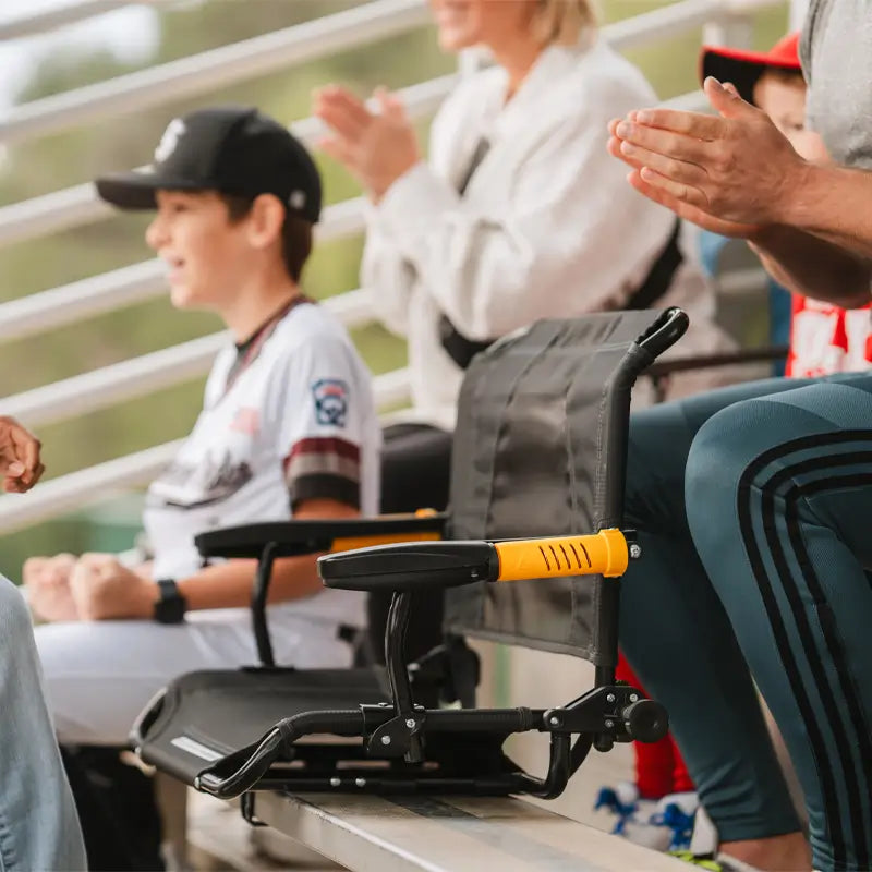 A woman placing a GCI Outdoor Stadium Rock-Cliner on bleachers near a young player, showing its portable, adjustable seat.