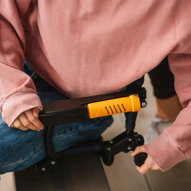 Close-up of a person adjusting the GCI Outdoor Stadium Rock-Cliner’s knob and armrest, showcasing its portable, rocking seat.