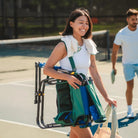 A woman carrying the pickleball stowaway rocker with a shoulder strap.