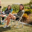 Two women sitting in comfort pro rockers watching a soccer game. 