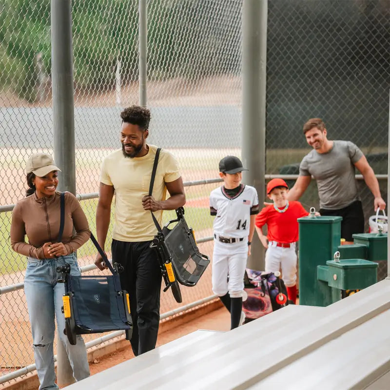 A couple walking towards bleachers with their stadium rock-cliner. 
