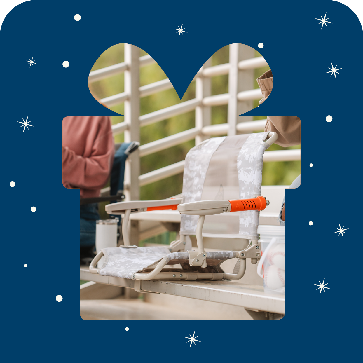 A gift box shaped outline with a stadium rock-cliner inside the gift. 