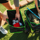A man reaching for a bag of baseballs as he holds the detached bumper caddy compartment. 