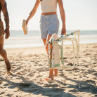 A woman carrying the Grab and Go Rocker floral bouqet by the carry strap. 