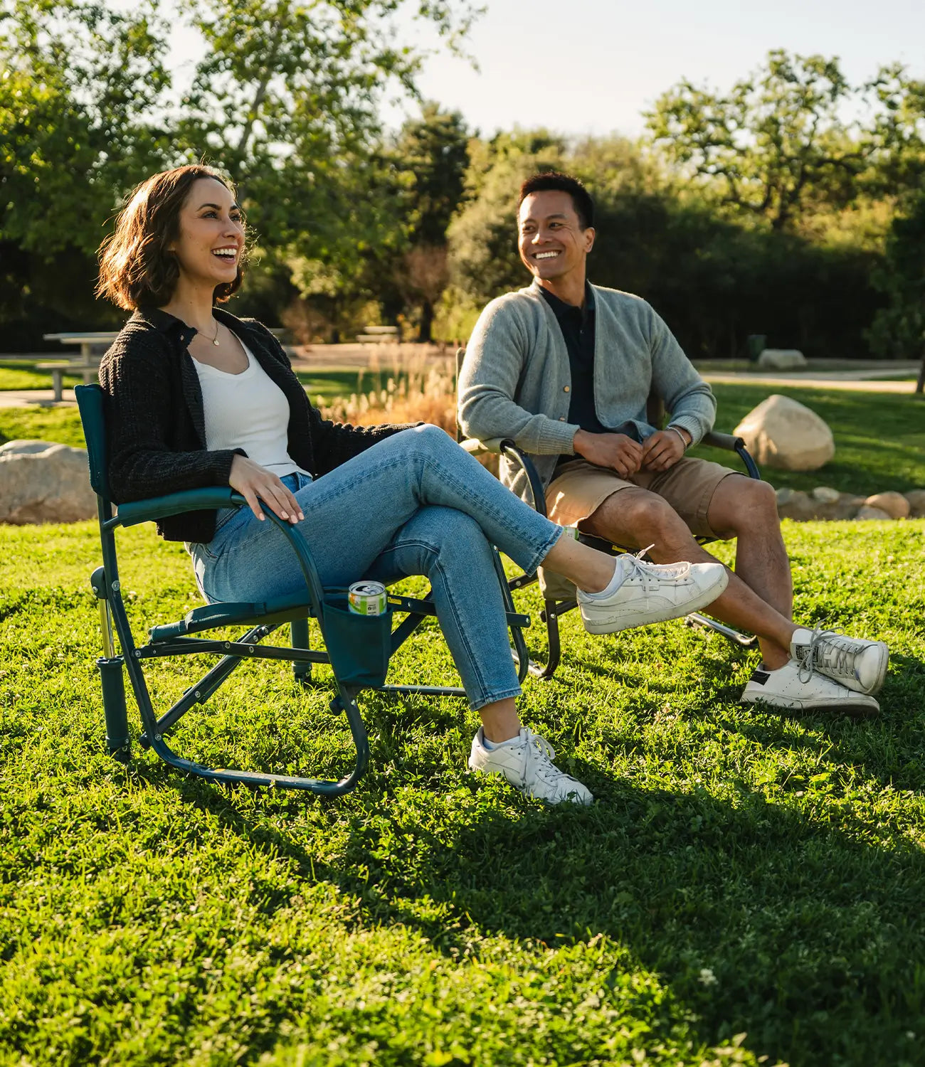A couple sitting together at a park in their teal Grab and Go Rockers. 