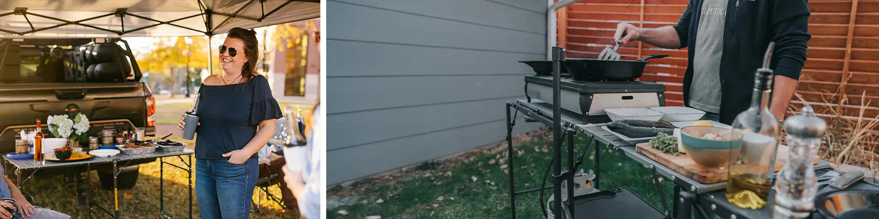 A woman standing by a slim-fold table at a tailgate and a man cooking on the master cook station. 