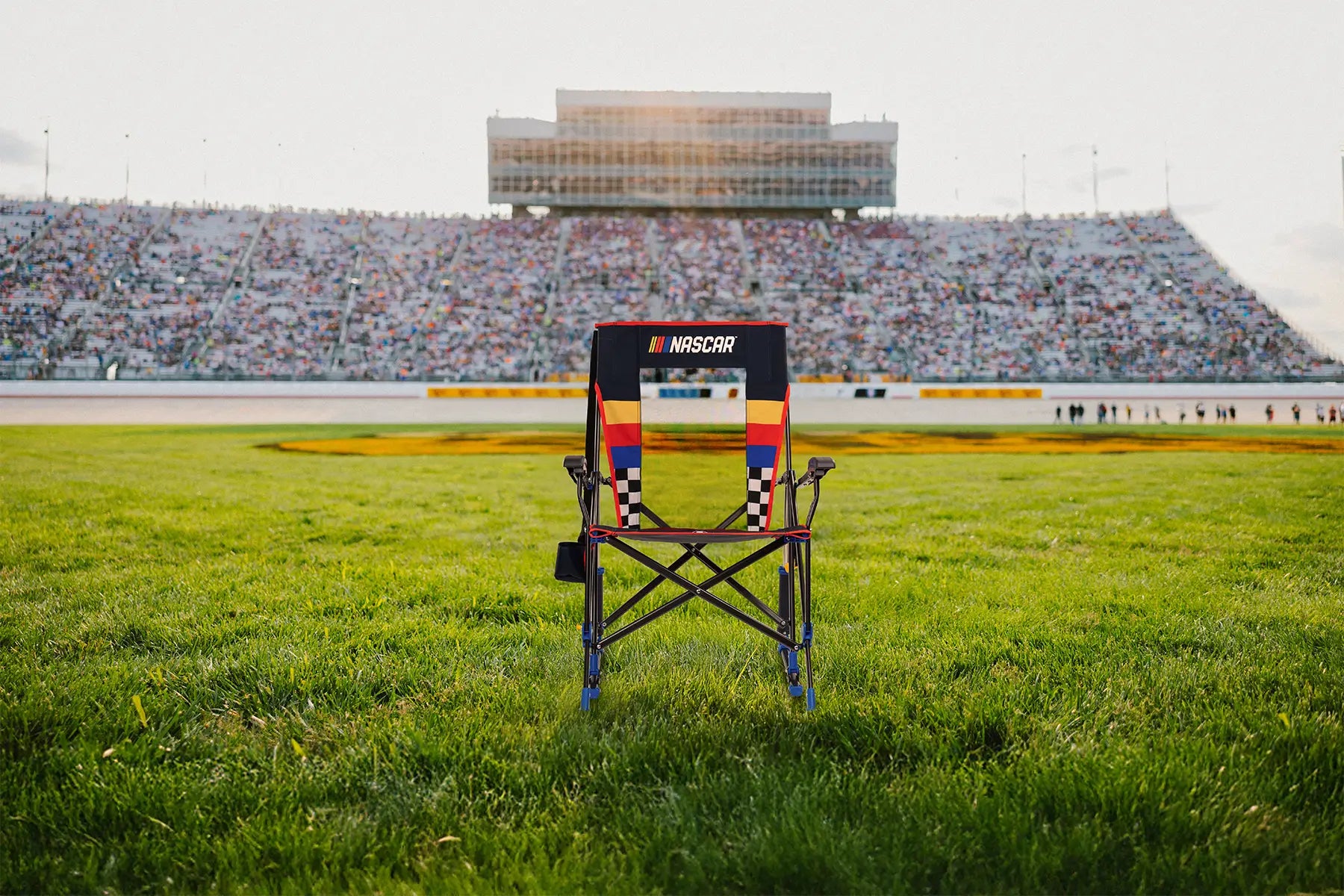 A NASCAR Roadtrip Rocker positioned in front of a racetrack. 