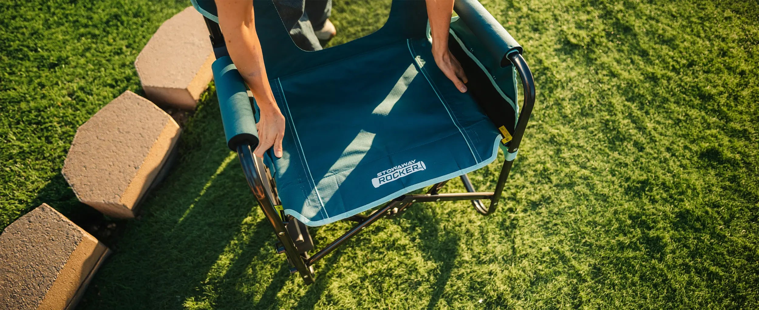The teal Stowaway Rocker with Side Table being unfolded. 