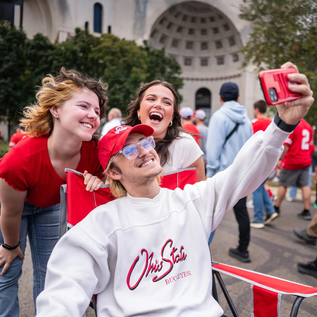 A group of students taking a picture with a man sitting in an ohio state comfort pro rocker chair. 