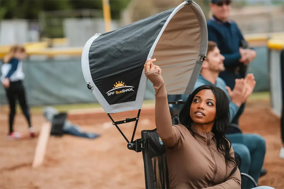 Featured image of a person relaxing in a rocker under a sunshade at a ball field