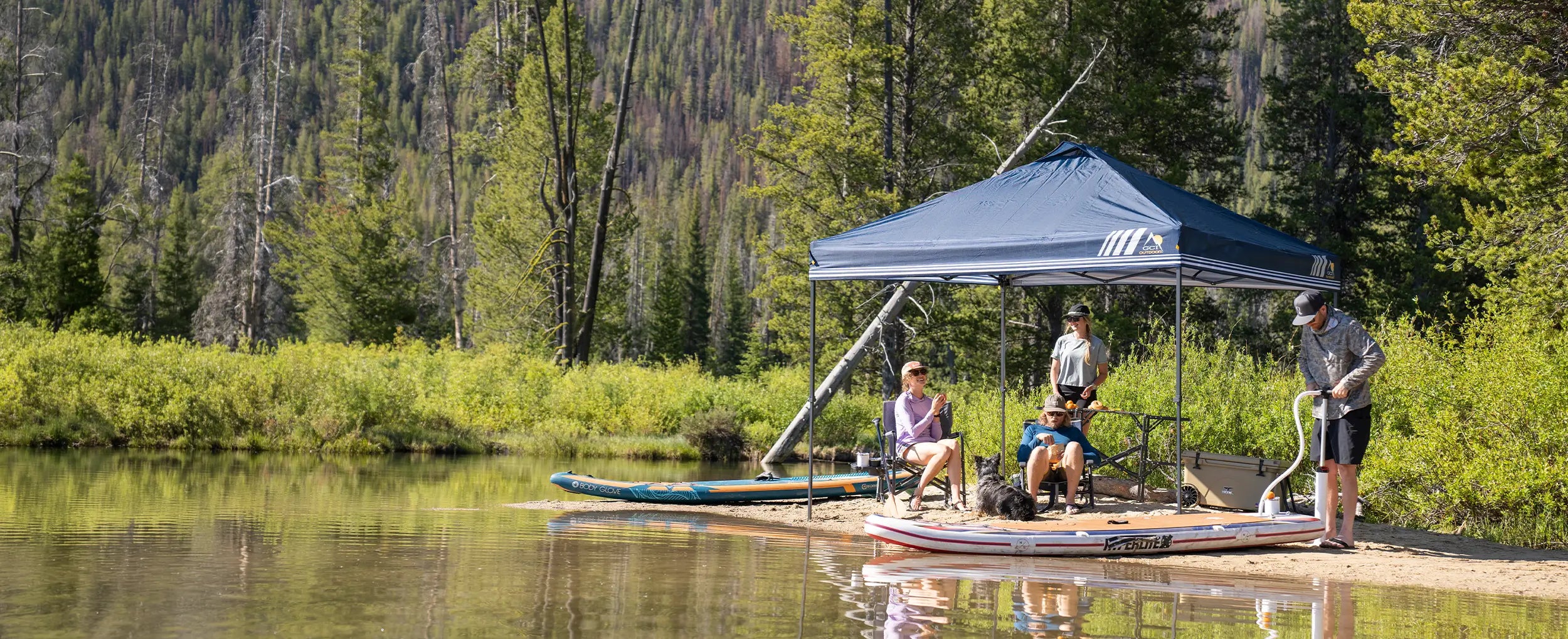 A group of kayakers on a sandbank relaxing underneath a blue Levrup Canopy. 