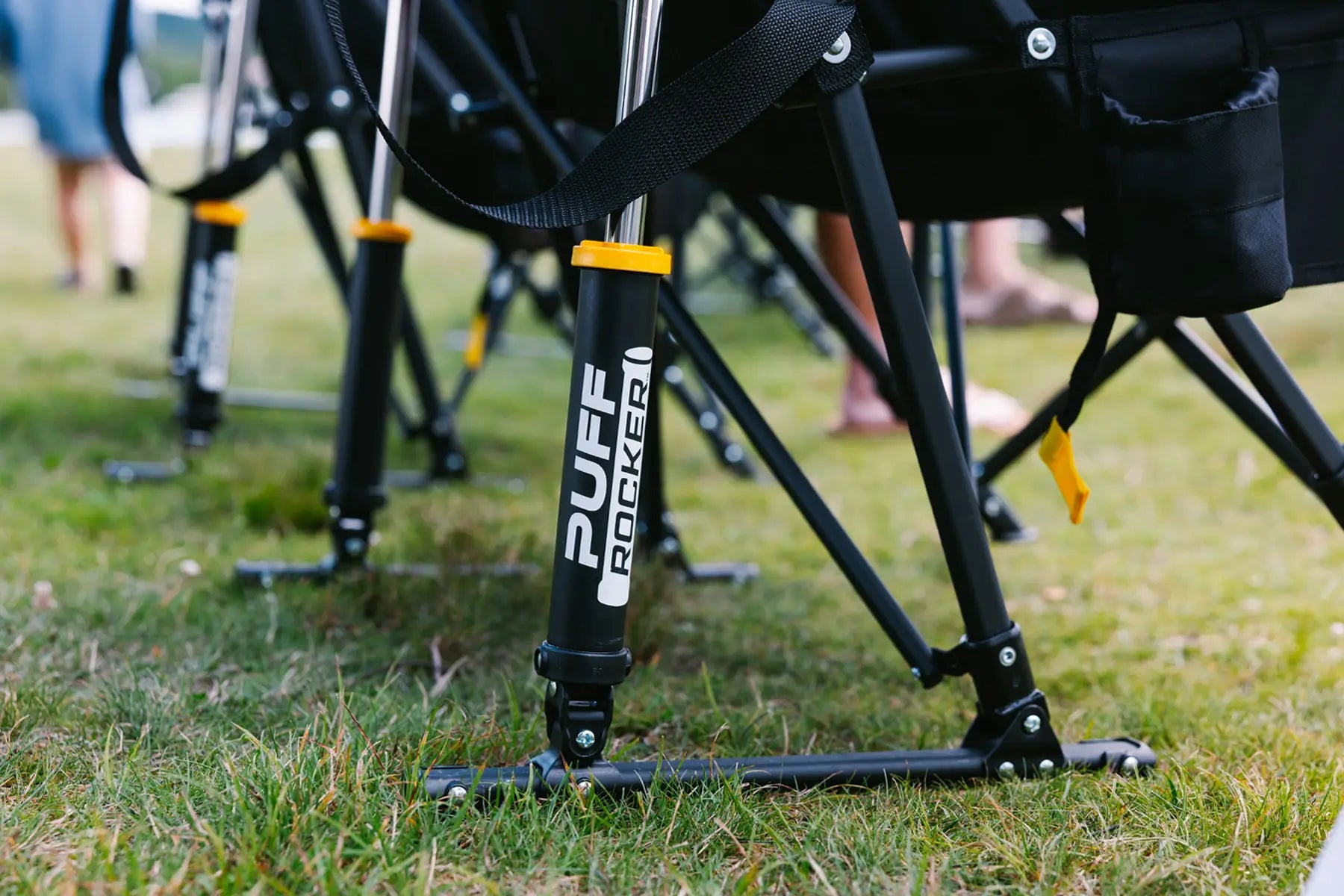 Close-up of the Puff Rocker’s frame and suspension system, with people standing nearby.