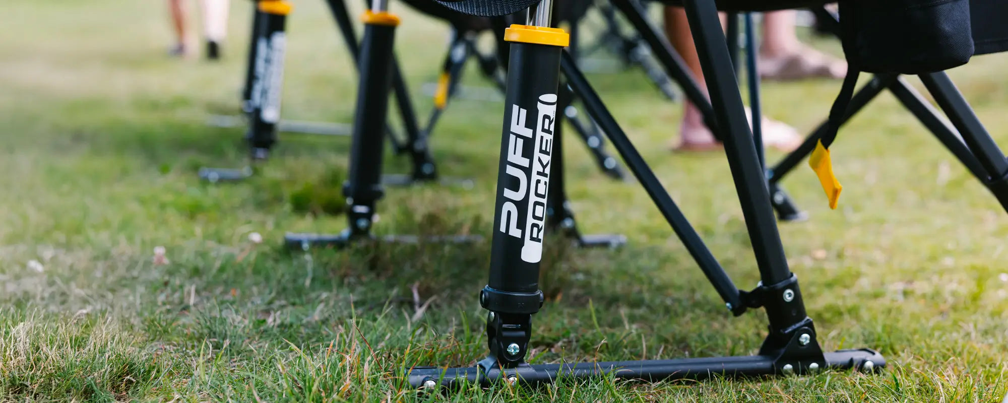 Close-up of the Puff Rocker’s frame and suspension system, with people standing nearby.