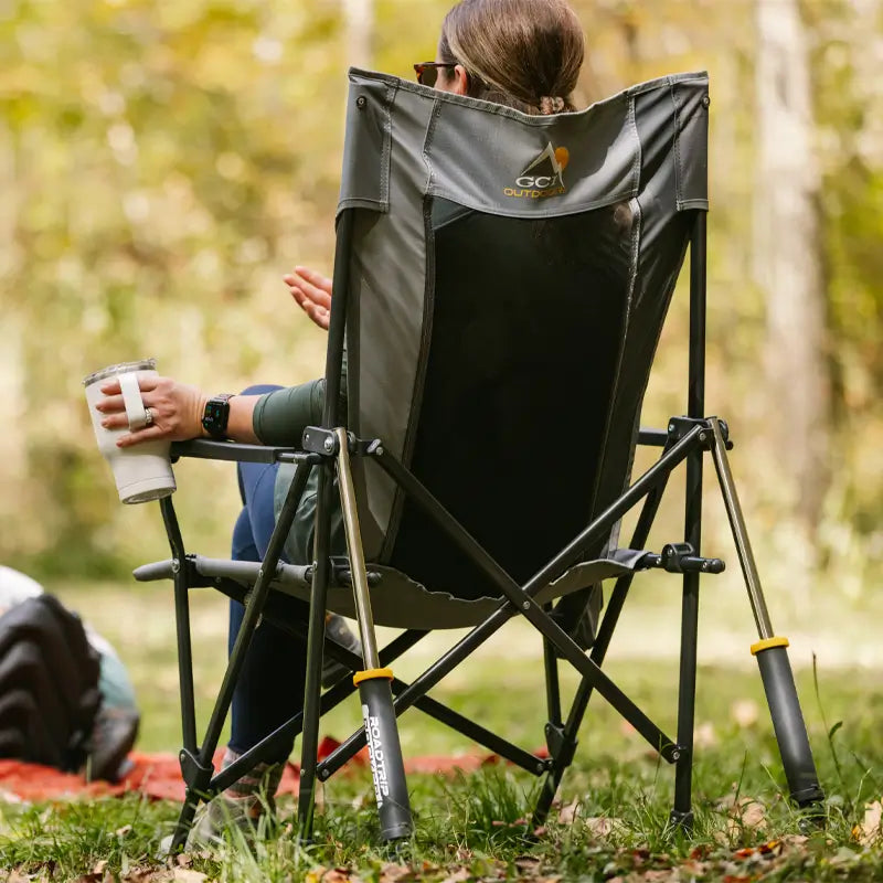 Close-up of a woman in a mercury gray Roadtrip Rocker holding a white tumbler in a forest setting.