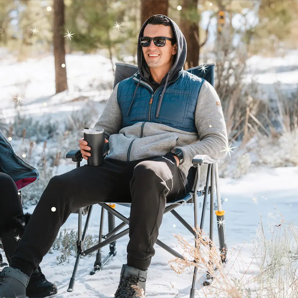 A man with a hoodie sitting in a roadtrip rocker chair. 