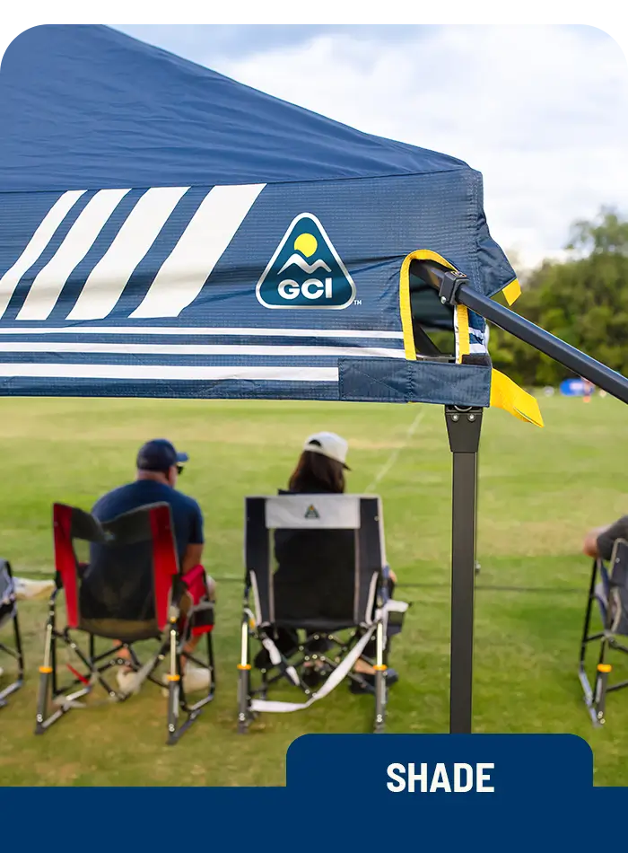 A LevrUp Canopy set up at a sports field, providing ample shade while spectators enjoy the game from their portable chairs.