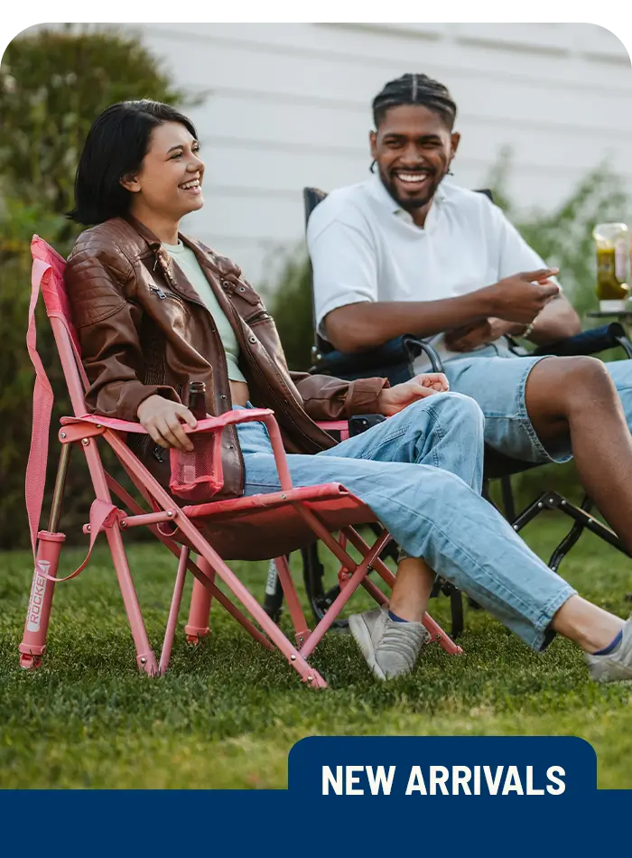 A couple relaxes in a Comfort Pro Rocker and Stowaway Rocker on their patio, enjoying the outdoors in comfortable, portable seating.