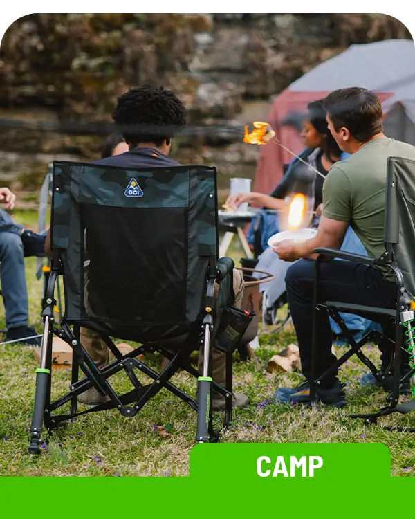A group gathered around a campfire roasting marshmallows while sitting in gci outdoor chairs. 