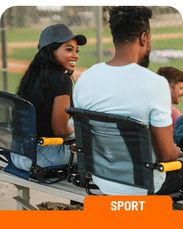 A couple sitting in two Stadium Rock-Cliners on a stadium bench. 