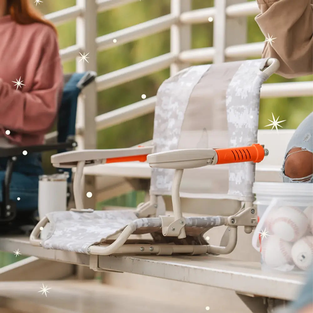 An up close shot of the snow camo stadium rock-cliner positioned on a bleacher. 
