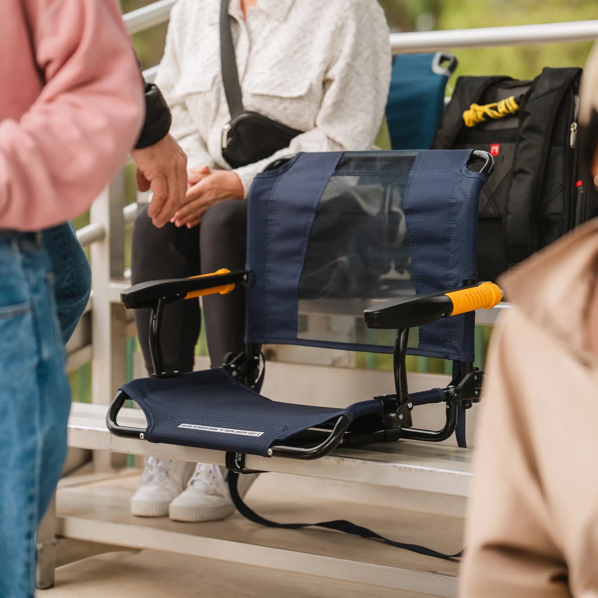 An indigo Stadium Rock-Cliner chair positioned on a set of bleachers. 