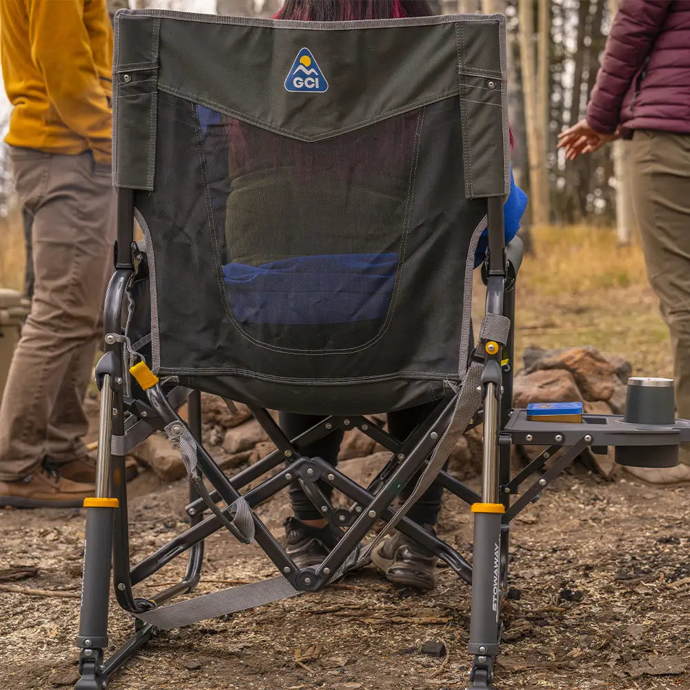 Rear view of the Black Stowaway Rocker with Side Table set up at a campsite.