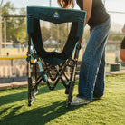 Back view of the Teal Stowaway Rocker showing the back while being moved outdoors.
