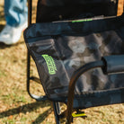 Close-up of the stealth camo Stowaway Rocker seat with a visible "Stowaway Rocker" logo in green.