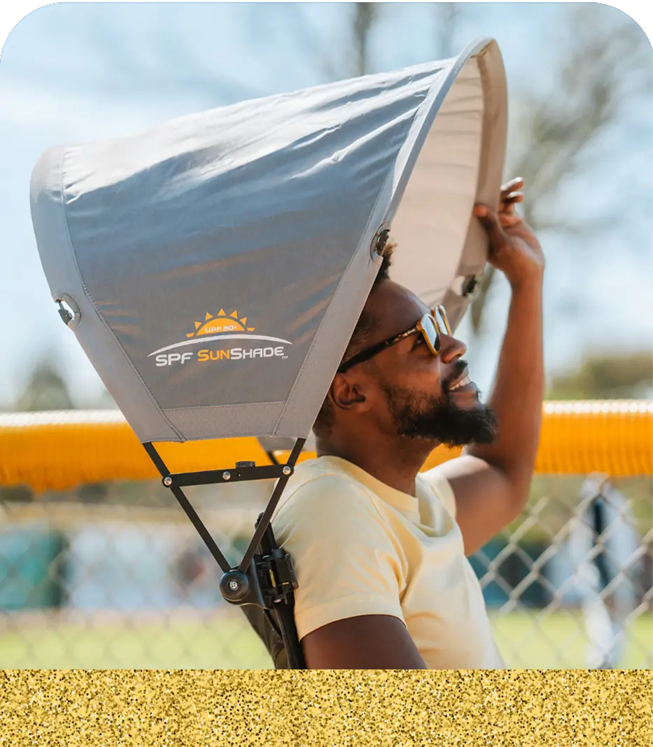 A man sitting in a GCI Outdoor chair positioning his sunshade accessory attached to the chair. 