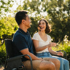 A man and woman laughing together as they sit on a Tandem Rocker. 
