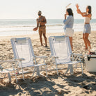 Two GCI Big Surf chairs in light blue mosaic set up near a cooler, with three people playing frisbee in the background.