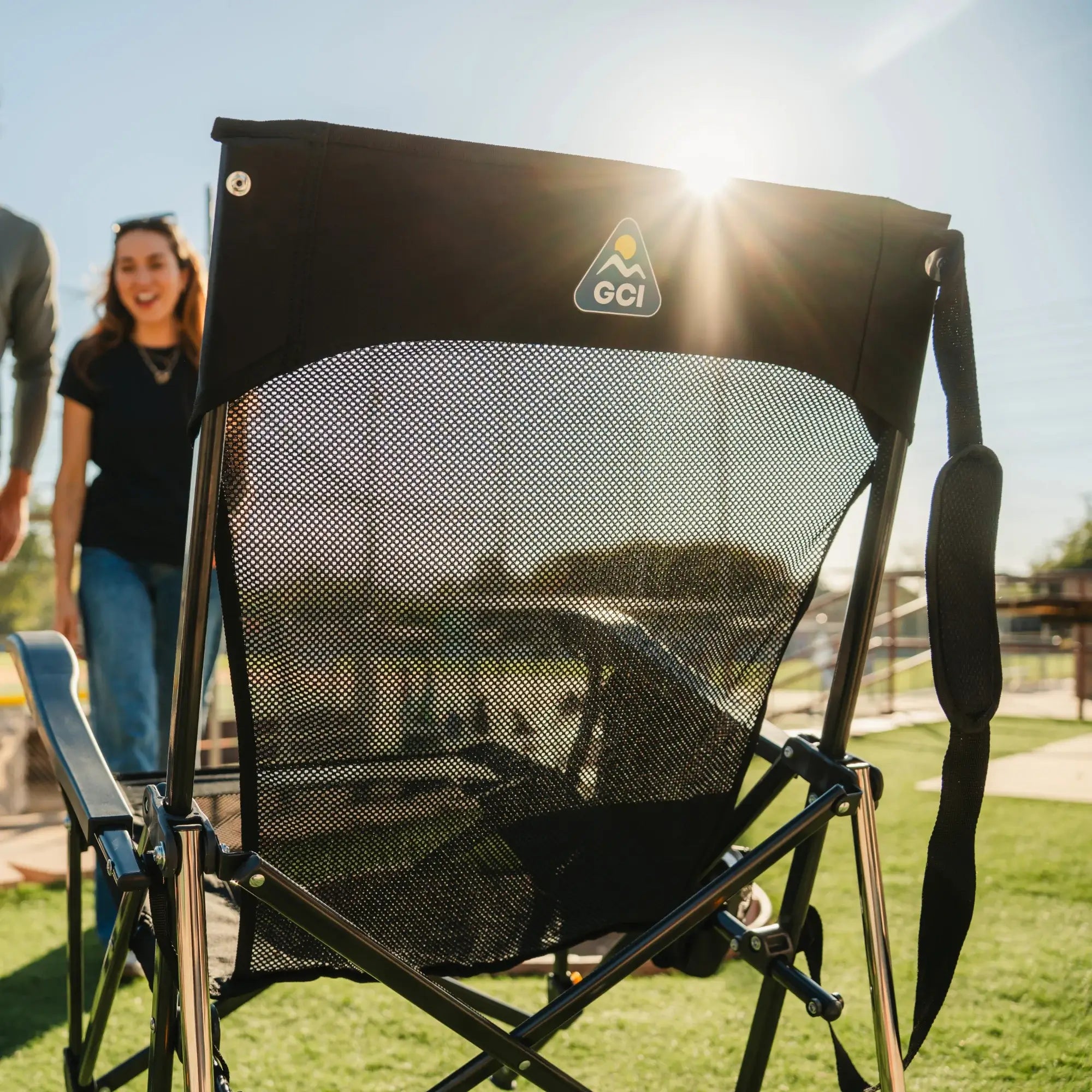 Front view of the Black Breeze Rocker set up on grass in bright sunlight at a baseball field.