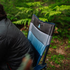 Close-up of the insulated backrest on the indigo Comfort Pro Insulated Rocker, with GCI logo visible, next to a person in a puffer jacket.