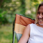 Close-up of a woman smiling while seated in an olive Comfort Pro Insulated Rocker.