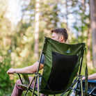 Back view of a man seated in a heathered olive Comfort Pro Rocker XL, with GCI logo visible on the backrest.