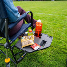Close-up of the Side Table on an indigo Freestyle Rocker XL, holding snacks and drinks beside a seated person.