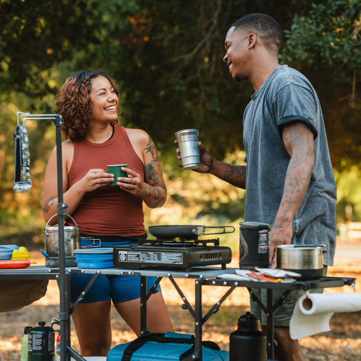 A couple laughing together while cooking on the master cook station. 