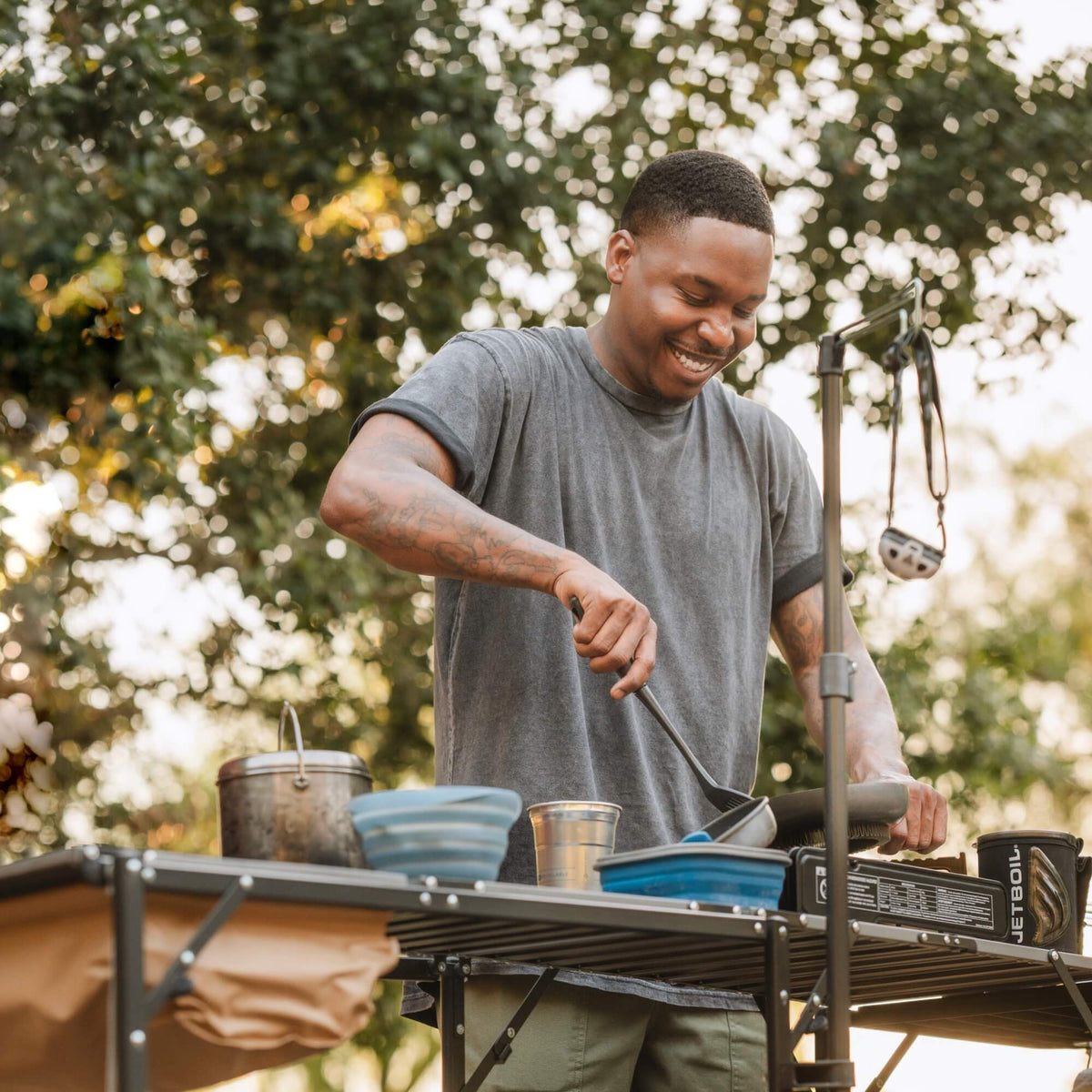 A man smiling and cooking with a stove on the Master Cook Station. 