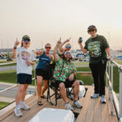 Group of NASCAR fans cheering on a viewing platform with a GCI Outdoor chair.