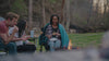 A group of people surrounding a firepit sitting in GCI Outoor rocking chairs and eating smores. 