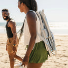 Close-up of the Sidekick heathered light blue backpack beach chair folded and worn over the shoulder.
