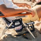 Close-up of TidalDrift beach chair's insulated cup holder pouch and wood armrest.