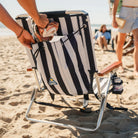 Back pocket storage on TidalDrift indigo stripe backpack beach chair holding a towel.